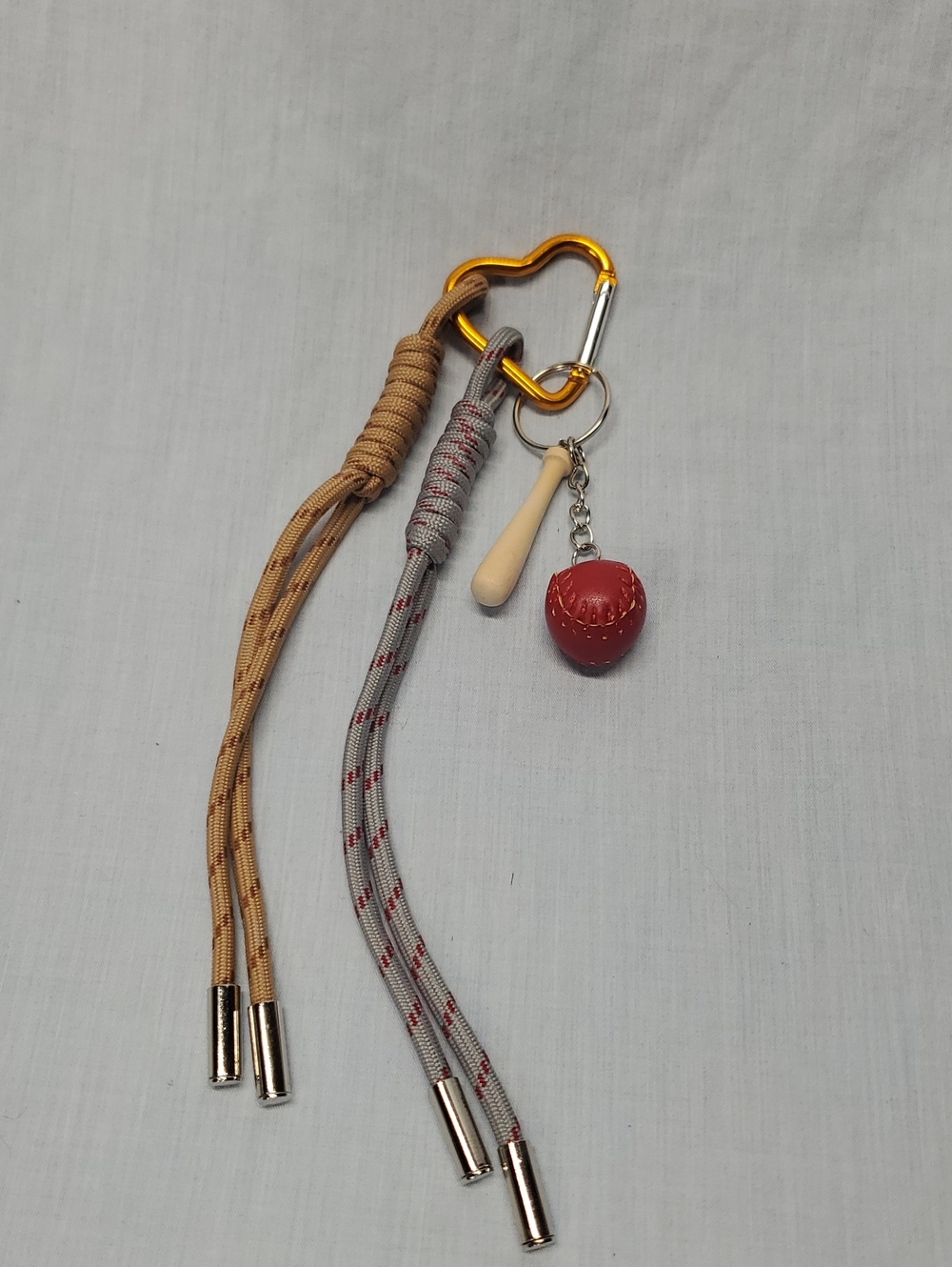 Gold Carabiner Keychain with Beige and Gray Tassels and Red Charm
